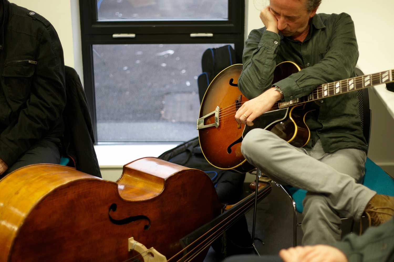 Dave Kelbie backstage playing guitar with Django a la Creole