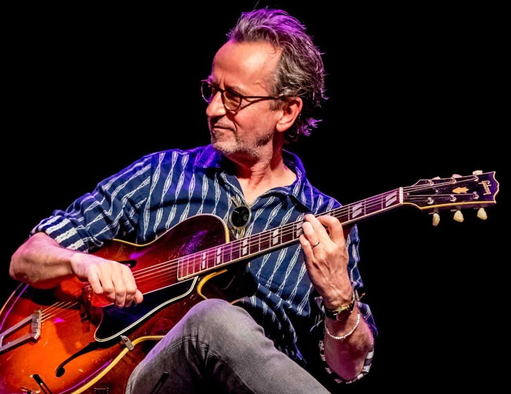 Dave Kelbie on stage playing guitar with The Dime Notes