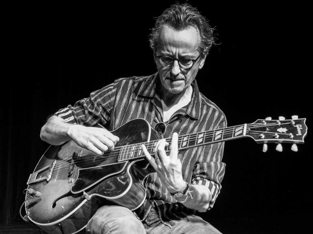 Dave Kelbie on stage playing guitar with The Dime Notes