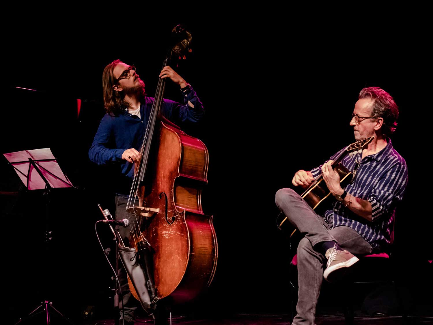 Louis Thomas, Dave Kelbie playing guitar on stage with Louis Thomas