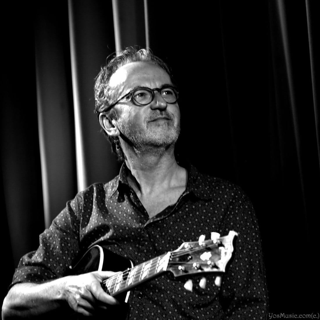 Dave Kelbie on stage playing guitar