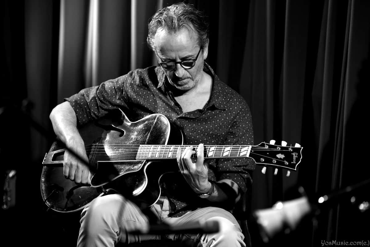 Dave Kelbie on stage playing guitar