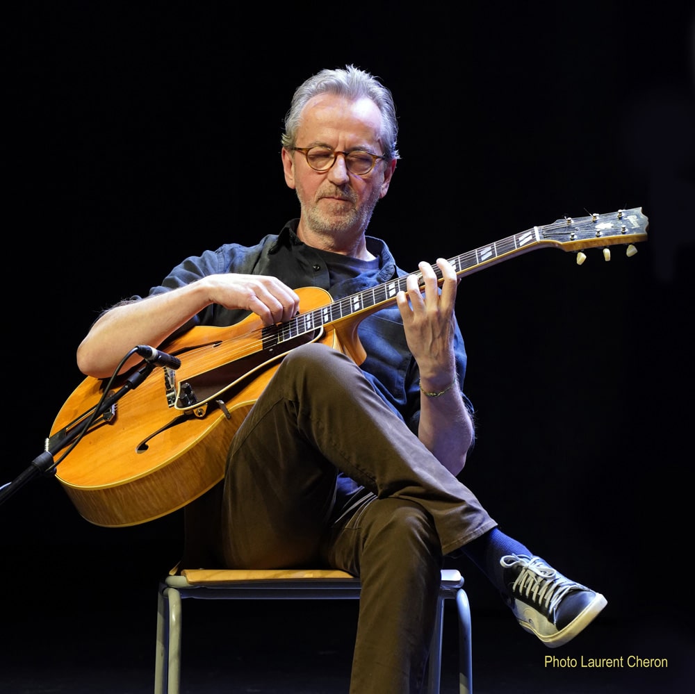 Dave Kelbie on stage playing guitar