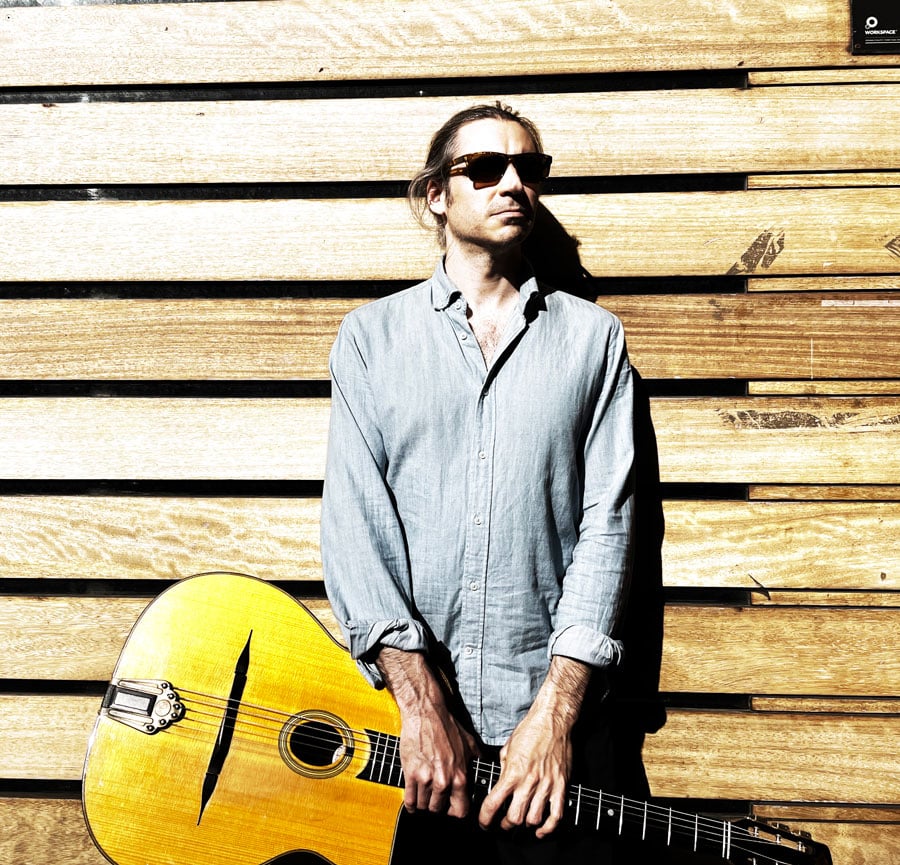 UK Guitarist John Kelly portrait with wooden background by Dave Kelbie